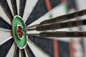 Darts hitting bull's eye on the dartboard