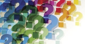 Colorful paper transparent question marks in corner on white background.