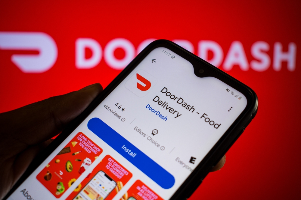 Man holds smartphone with DoorDash app on Google Play. DoorDash, Inc. is an American company operating online food ordering and food delivery and tops Morning Consult's 2025 Fastest Growing Brands in the U.S.